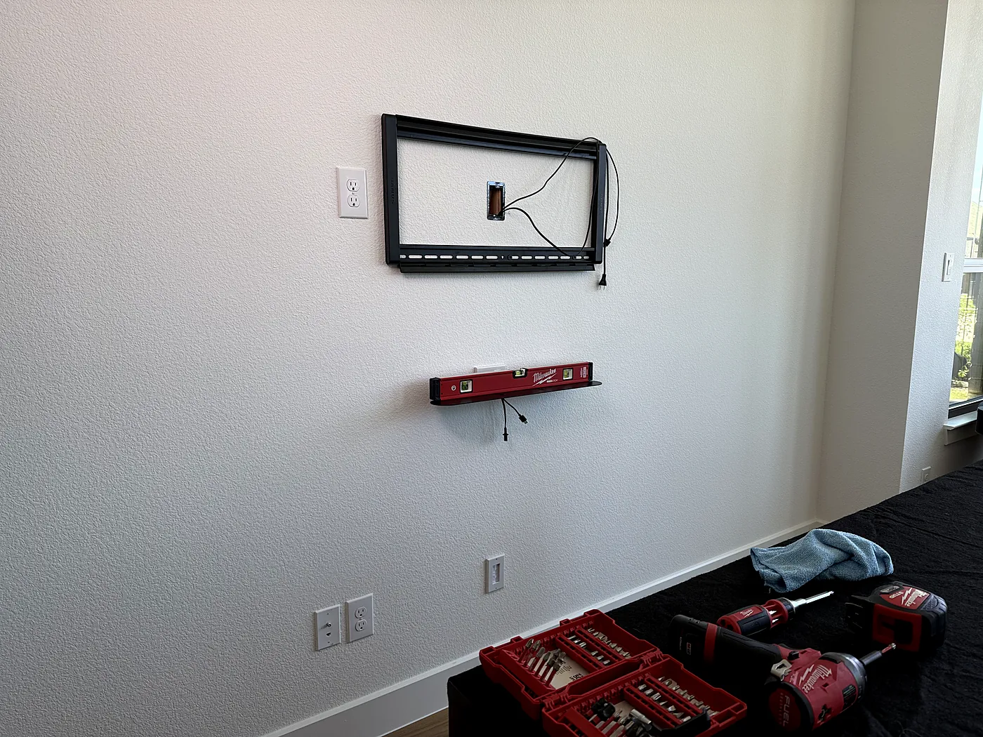 Mounted TV bracket with cables routed to a nearby wall outlet for in-wall concealment